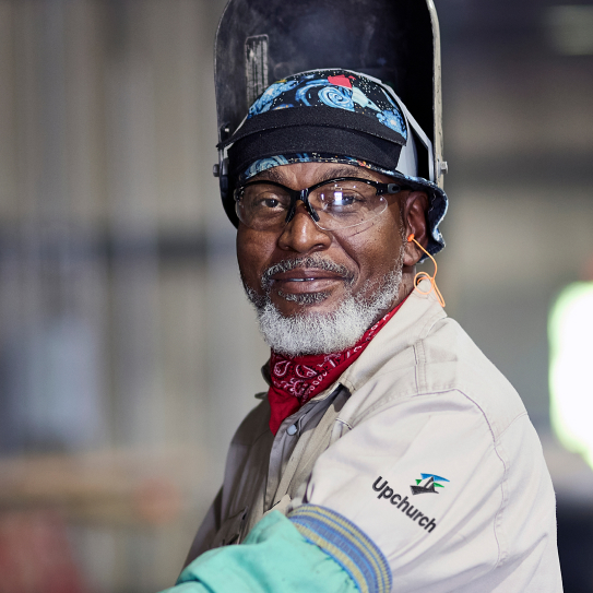 Upchurch shop floor employee wearing safety equipment, looking at the camera